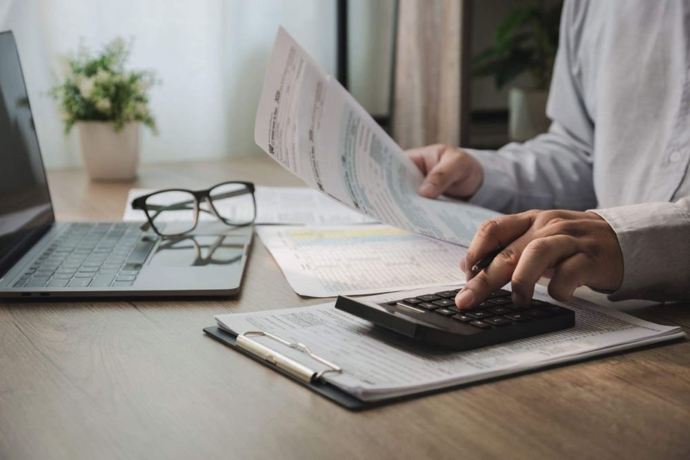 Man uses calculator for law firm invoice management