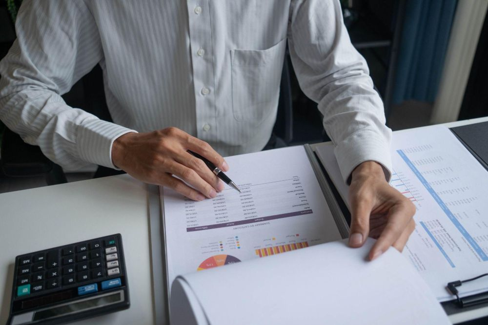 a man in a white shirt is holding a pen and paper