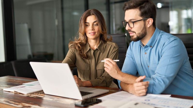 Man and woman reviewing financial data on a laptop,