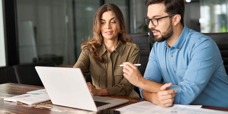 Man and woman reviewing financial data on a laptop,
