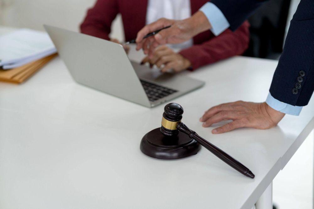 Two people reviewing documents on a laptop with