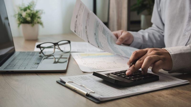Man uses calculator for law firm invoice management