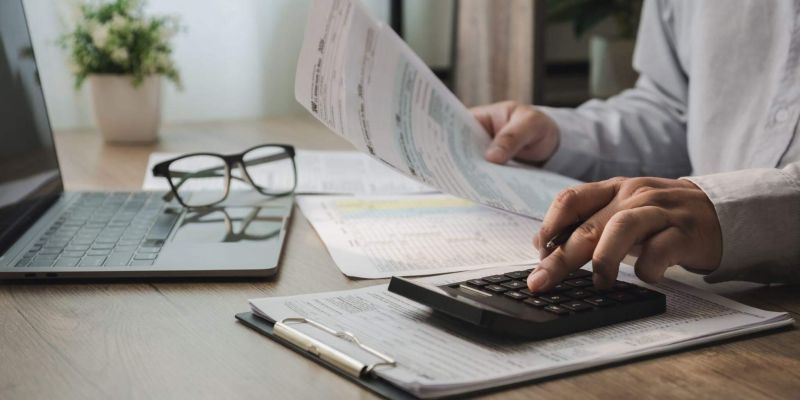 Man uses calculator for law firm invoice management