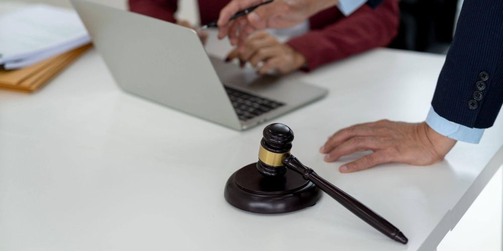Two people reviewing documents on a laptop with