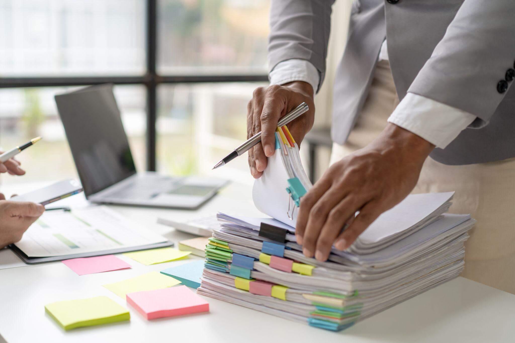 a man is taking notes from a stack of sticky notes