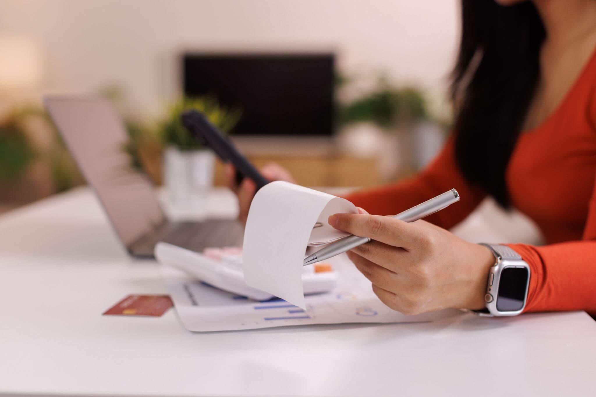 Woman on laptop, likely performing bookkeeping or