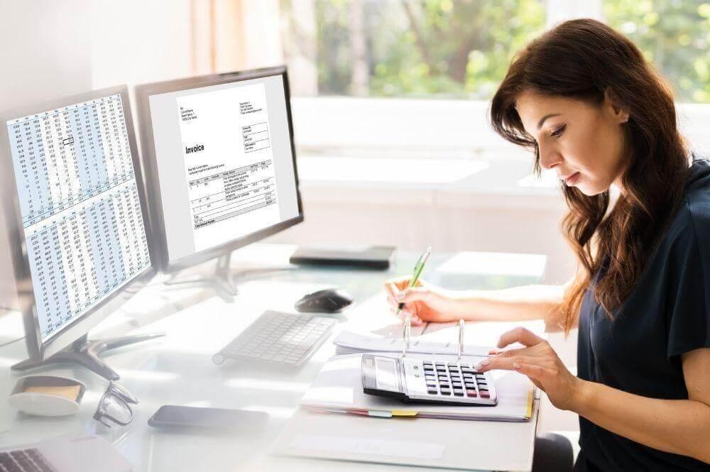 Woman using a calculator at a desk, representing fractional