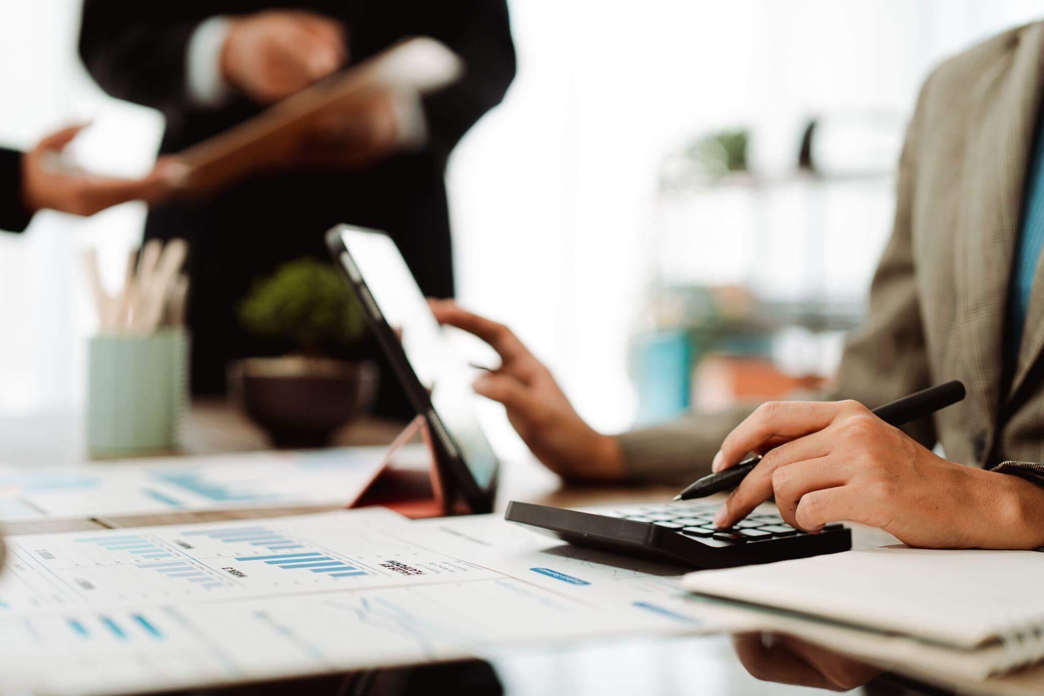 Person using a calculator to manage invoices at
